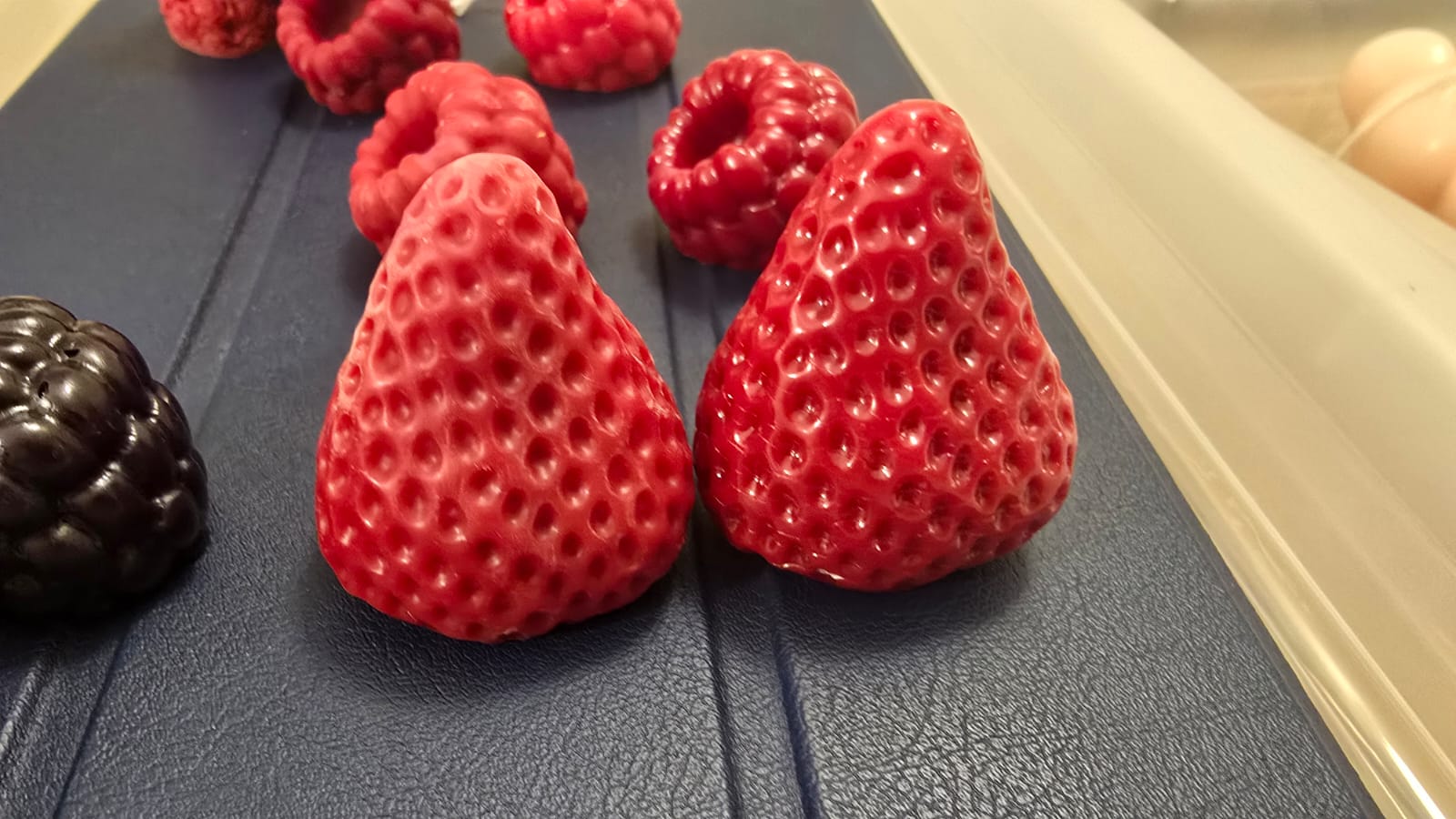 Wachserdbeeren vor und nach dem finalen Lackieren nebeneinander