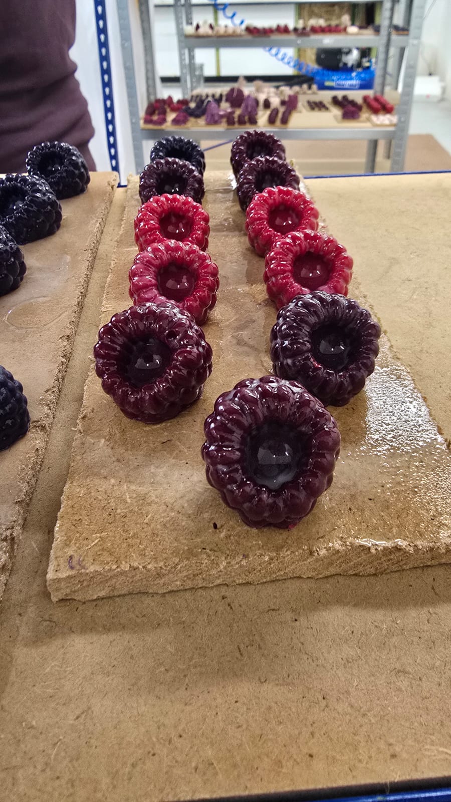 Wachskerzen in Form von Himbeeren nach dem Lackieren, glatte glänzende Oberfläche