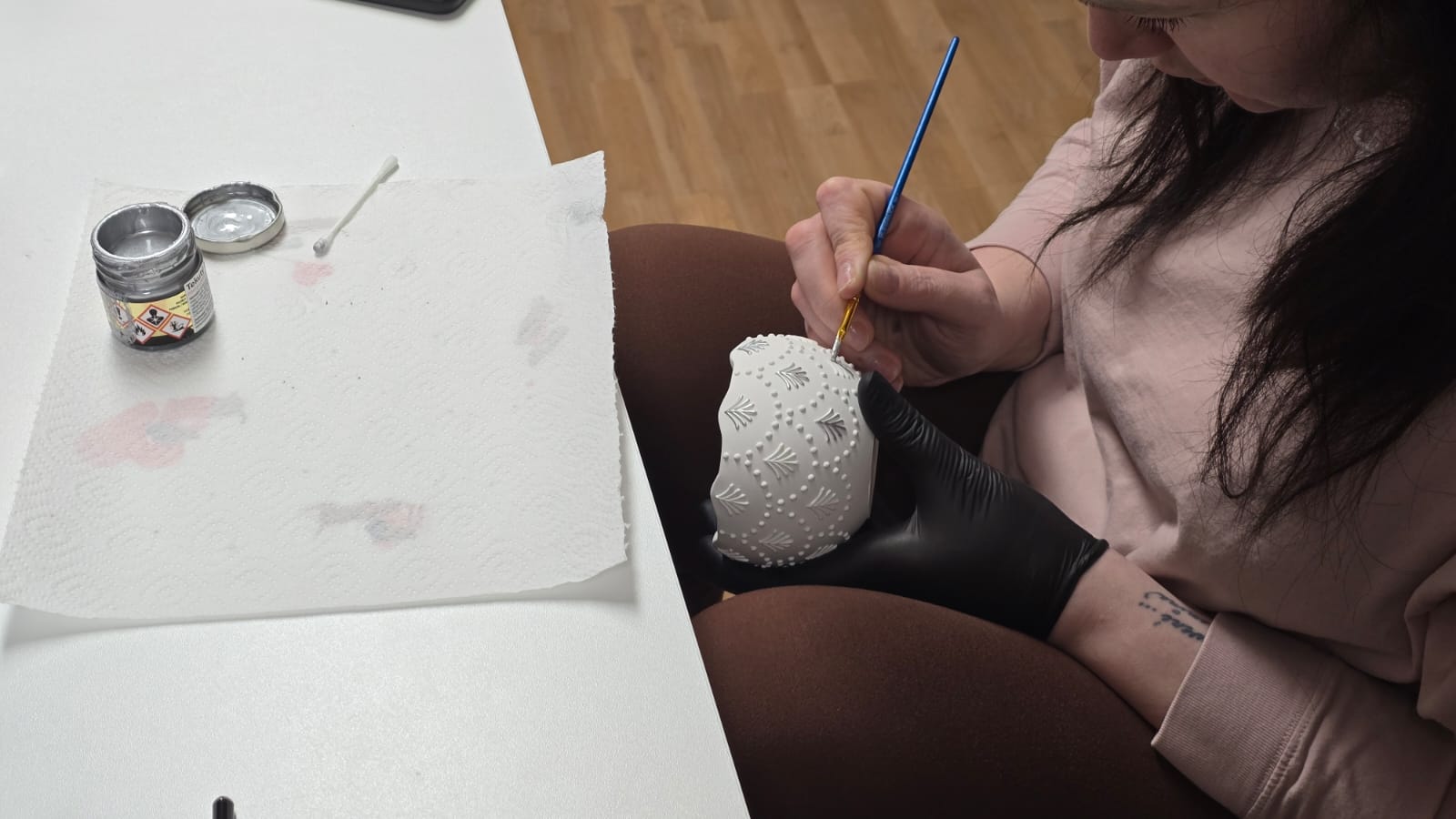 Handbemalung silberner Ornamente mit einem feinen Pinsel