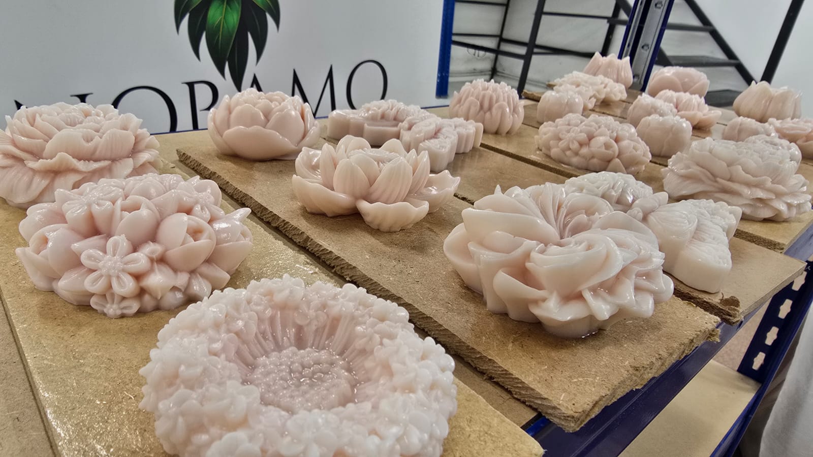Kerzen in Form von Blumen und dekorativen Vasen, bereit für das Regal