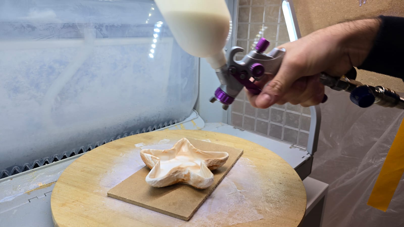 Professionelles Sprühen des Kerzenbehälters in der Lackierkabine